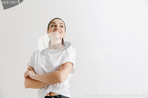 Image of The happy woman standing and smiling against gray background.