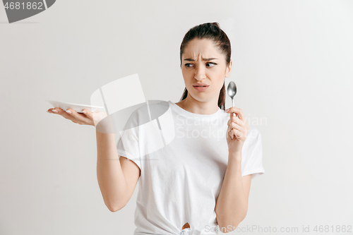 Image of Young fun crazy brunette housewife with spoon isolated on white background