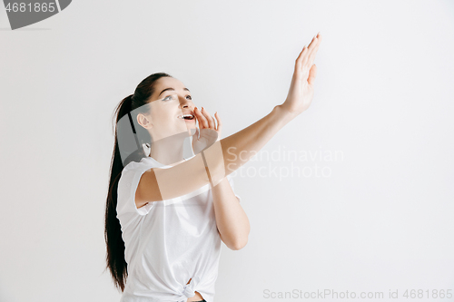 Image of Isolated on gray young casual woman shouting at studio