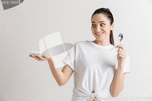 Image of Young fun crazy brunette housewife with spoon isolated on white background