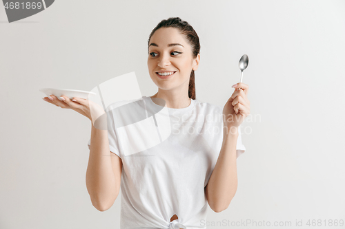 Image of Young fun crazy brunette housewife with spoon isolated on white background