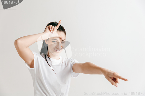 Image of Losers go home. Portrait of woman showing loser sign over forehead