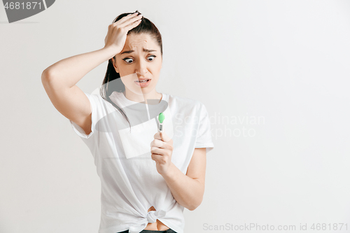 Image of Young woman looking on pregnancy test