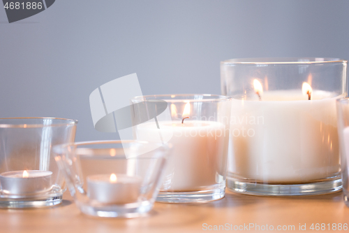 Image of burning white fragrance candles on wooden table