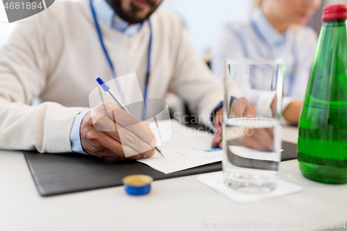 Image of businessman with papers at business conference