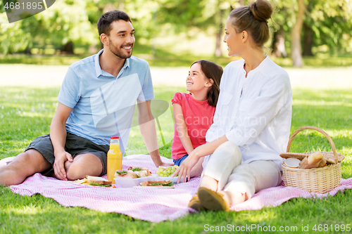 Image of happy family having picnic at summer park