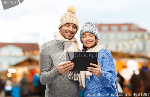 Image of couple with tablet computer at christmas market