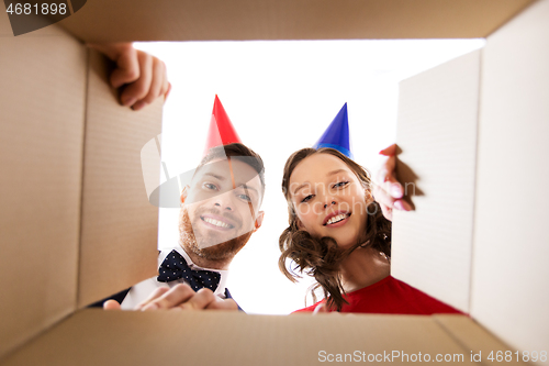 Image of couple in party hats opening birthday gift box