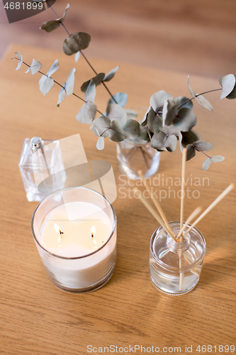 Image of aroma reed diffuser, burning candle and perfume