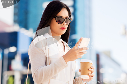 Image of woman with smartphone and coffee in city