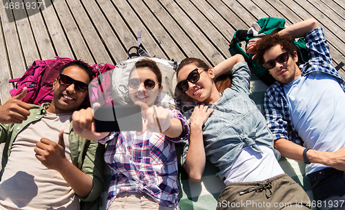 Image of friends or tourists with backpacks taking selfie