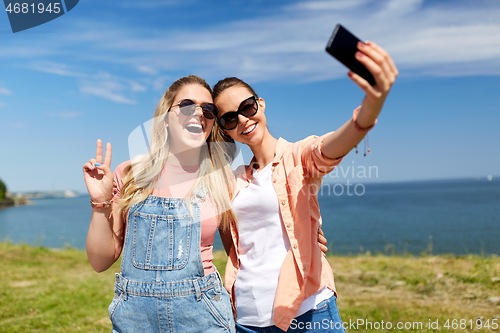 Image of teenage girls or friends taking selfie in summer
