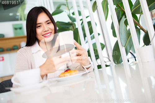 Image of asian woman with smartphone at cafe or coffee shop