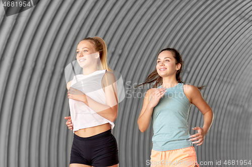 Image of young women or female friends running outdoors