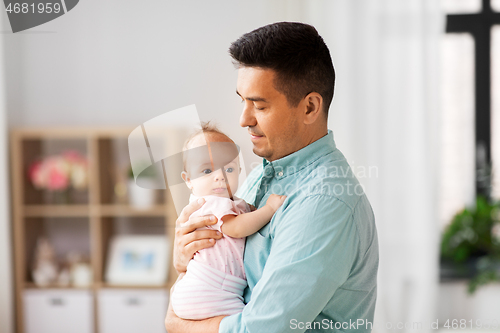 Image of middle aged father with baby daughter at home