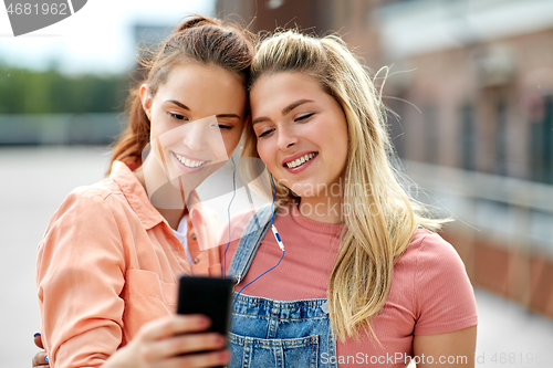 Image of teenage girls listening to music on smartphone