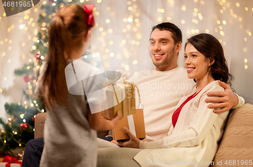 Image of happy family with christmas present at home