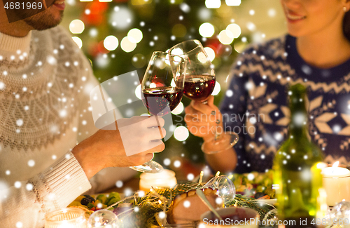 Image of happy couple drinking red wine at christmas dinner