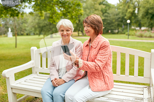 Image of happy senior women with smartphone at summer park