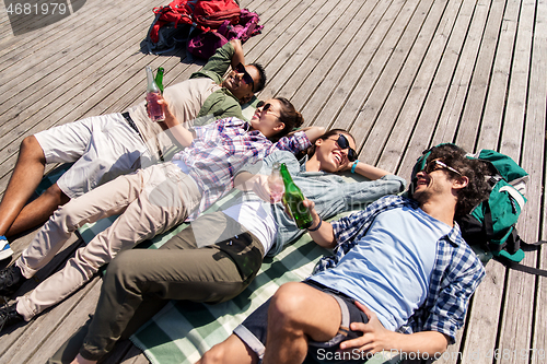 Image of friends drinking beer and cider on wooden terrace