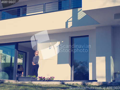 Image of women using tablet computer in front of luxury home villa