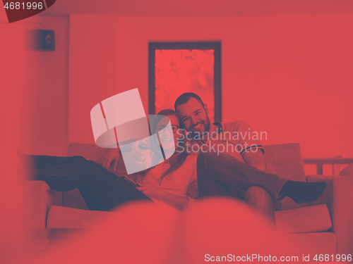 Image of Young couple on the sofa watching television