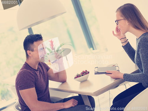 Image of couple enjoying morning coffee and strawberries