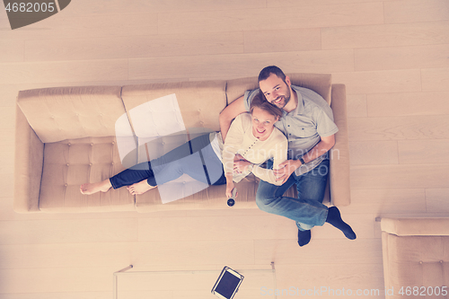 Image of romantic couple on the sofa watching television top view