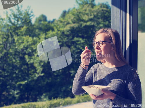 Image of woman eating breakfast in front of her luxury home villa