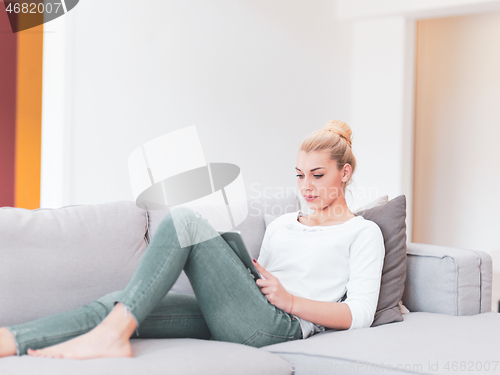 Image of woman on sofa using tablet computer