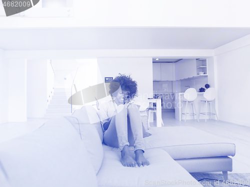 Image of african american woman at home using digital tablet