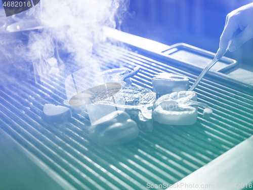 Image of chef cooking steak with vegetables on a barbecue