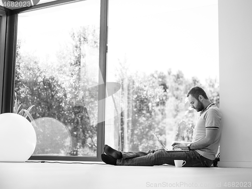 Image of man drinking coffee on the floor enjoying relaxing lifestyle