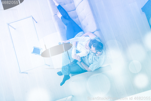 Image of romantic couple on the sofa watching television top view