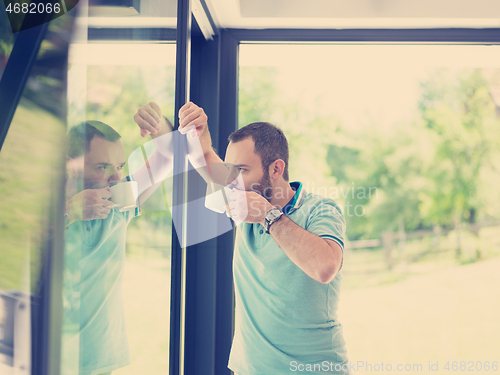 Image of young man drinking morning coffee by the window