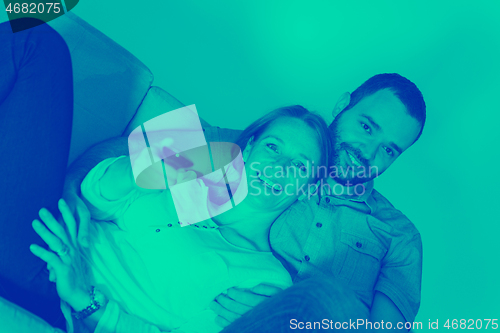 Image of romantic couple on the sofa watching television