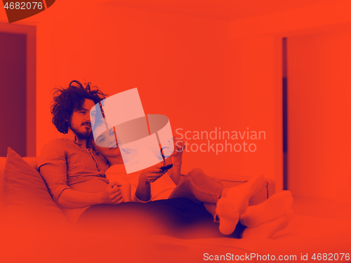 Image of Young couple on the sofa watching television
