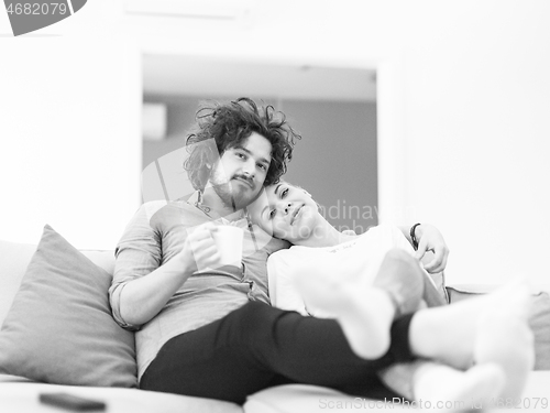 Image of Young couple on the sofa watching television