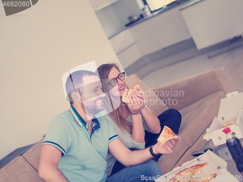 Image of couple eating pizza in their luxury home villa