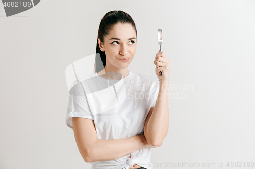 Image of Young fun crazy brunette housewife with fork isolated on white background