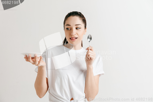 Image of Young fun crazy brunette housewife with spoon isolated on white background