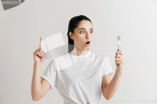 Image of Young fun crazy brunette housewife with fork isolated on white background