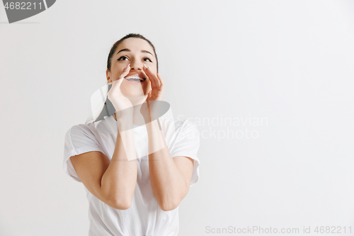 Image of Isolated on gray young casual woman shouting at studio