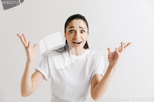 Image of Beautiful woman looking suprised and bewildered isolated on gray