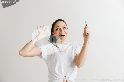 Image of Smiling young woman looking on pregnancy test