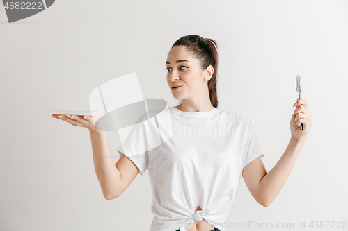 Image of Young fun crazy brunette housewife with fork isolated on white background