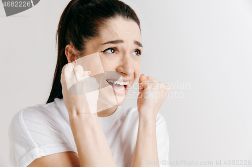 Image of Beautiful woman looking suprised and bewildered isolated on gray