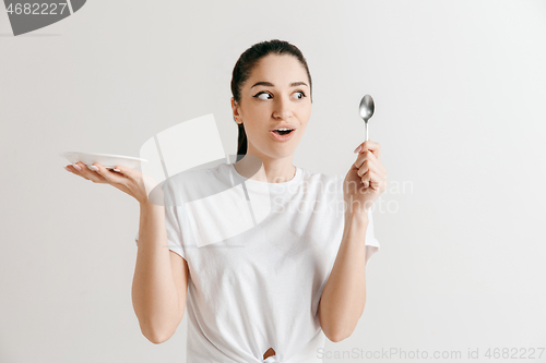 Image of Young fun crazy brunette housewife with spoon isolated on white background