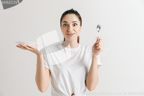 Image of Young fun crazy brunette housewife with spoon isolated on white background