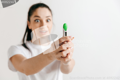 Image of Smiling young woman looking on pregnancy test